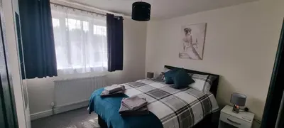 a bedroom with a bed with a blue blanket and a window at Shirely S, Milton, Cambridge, 2BR House, Newly Refurbished in Milton