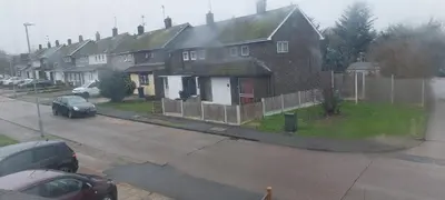 a group of houses with cars parked in a parking lot at Basildon House of Muralist in Basildon