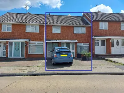 a blue car parked in front of a brick house at Basildon House of Muralist in Basildon