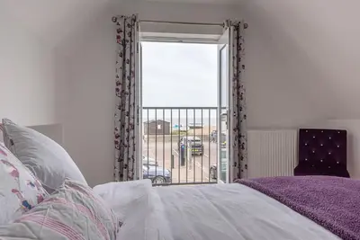 a bedroom with a bed and a sliding glass door at Guild House, Aldeburgh in Aldeburgh
