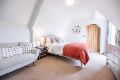 a white bedroom with a bed and a couch at Guild House, Aldeburgh in Aldeburgh