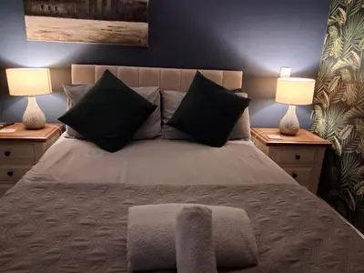 a bedroom with a bed with two lamps on both sides at Suite near City, Science Park & Marshalls and close to Riverside walks in Milton