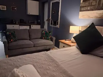 a living room with a bed and a couch at Suite near City, Science Park & Marshalls and close to Riverside walks in Milton
