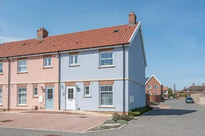 a white house with a red roof on a street at Alde Seagull, Aldeburgh in Aldeburgh