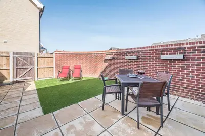 a patio with a table and chairs on a brick wall at Alde Seagull, Aldeburgh in Aldeburgh