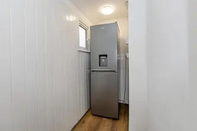a refrigerator in a room with a window at The Comfy Contractors Resort, Free Private Parking & Wifi, 7 beds in Colchester
