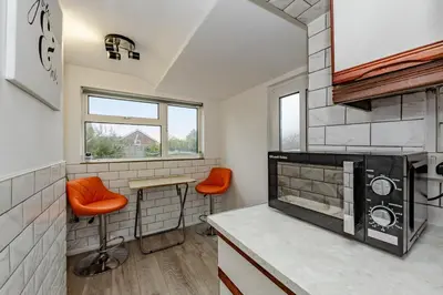 a kitchen with orange chairs and a stove at The Comfy Contractors Resort, Free Private Parking & Wifi, 7 beds in Colchester