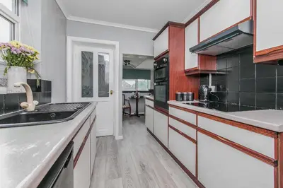 a kitchen with white cabinets and black appliances at The Comfy Contractors Resort, Free Private Parking & Wifi, 7 beds in Colchester