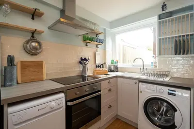 a kitchen with a sink and a dishwasher at Quay Cottage - Aldeburgh Coastal Cottages in Aldeburgh