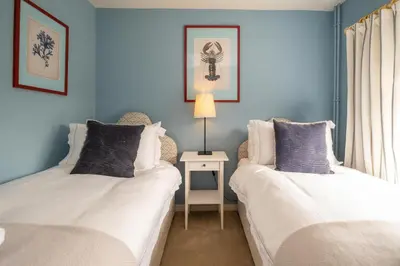 two beds in a room with blue walls at Quay Cottage - Aldeburgh Coastal Cottages in Aldeburgh