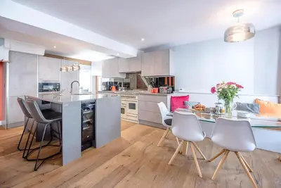 a kitchen with a counter and a table and chairs at The Picture House, Aldeburgh in Aldeburgh