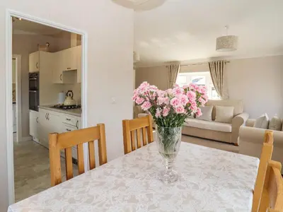 a vase of pink flowers on a table in a kitchen at 12 Bucklesham Park in Ipswich