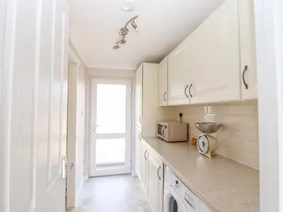 a kitchen with white cabinets and a microwave at 12 Bucklesham Park in Ipswich