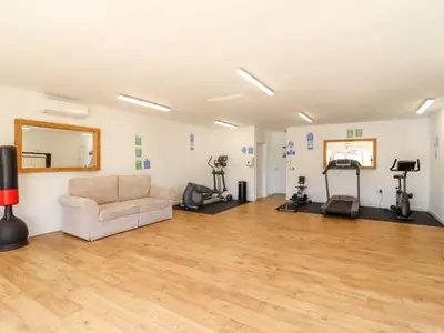 a living room with a couch and exercise equipment at 12 Bucklesham Park in Ipswich