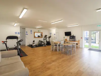 a living room with a couch and a table with exercise bikes at 12 Bucklesham Park in Ipswich