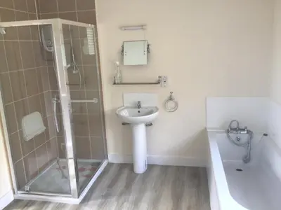 a bathroom with a sink and a shower and a toilet at Thatched Cottage in Wix