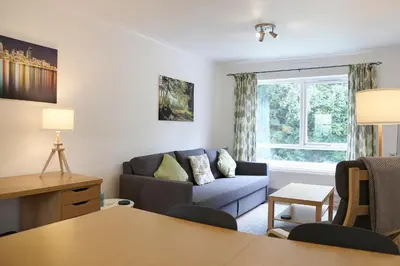 a living room with a blue couch and a window at Pass the Keys 1BR Modern Beautiful House Pass the Keys in Cambridge