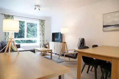 a living room with a table and chairs and a tv at Pass the Keys 1BR Modern Beautiful House Pass the Keys in Cambridge