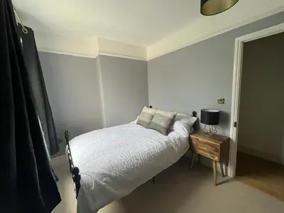 a bedroom with a bed and a table with a lamp at Charming 3 bedroom property in Bury St Edmunds in Bury Saint Edmunds
