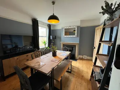 a dining room with a table and a fireplace at Charming 3 bedroom property in Bury St Edmunds in Bury Saint Edmunds
