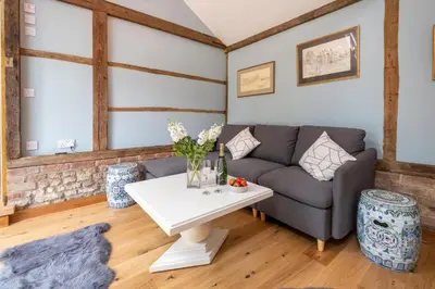a living room with a couch and a table at The Cart Lodge - Aldeburgh Coastal Cottages in Wickham Market
