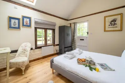 a bedroom with a bed and a desk and a chair at The Cart Lodge - Aldeburgh Coastal Cottages in Wickham Market