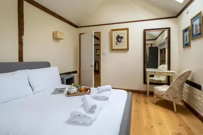 a bedroom with a white bed and a mirror at The Cart Lodge - Aldeburgh Coastal Cottages in Wickham Market