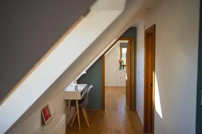 an attic room with a staircase with a desk and a table at The Pheasantry in Wymondham