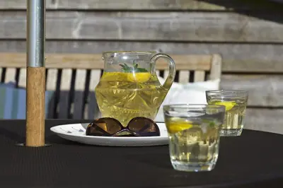 a glass pitcher of lemonade and glasses on a table at The Pheasantry in Wymondham