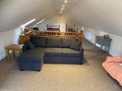 a living room with a couch in a attic at The Shed in Long Stratton