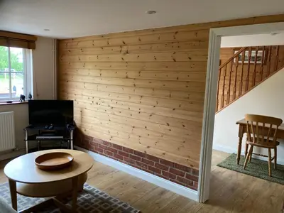 a living room with a wall of wood at The Shed in Long Stratton
