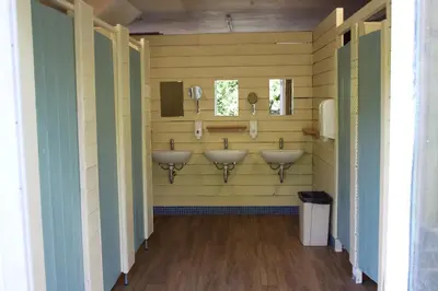 a bathroom with four sinks in a yellow wall at The Kestrel Shepherd Hut, Whitehouse Farm in Stowmarket
