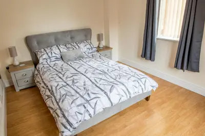 a bedroom with a bed with a gray headboard at Toothbrush Apartments - Central Ipswich - Gipping Mews in Ipswich