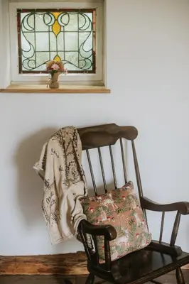 a blanket sitting on a chair next to a window at Cranfield Retreat & Glamping in Long Melford