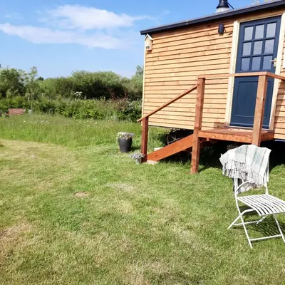 a couple of chairs sitting in front of a house at Cranfield Retreat & Glamping in Long Melford