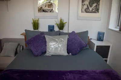 a bedroom with a bed with purple sheets and pillows at 121 Studio - Apartment with Kitchen, Terrace, Stansted Airport Shuttle in Bishops Stortford