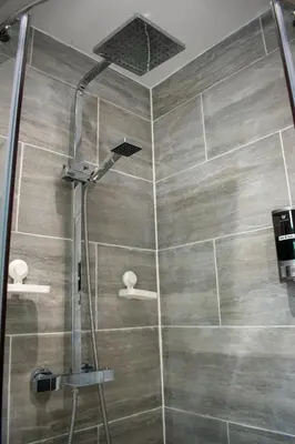 a shower with a shower head in a bathroom at 121 Studio - Apartment with Kitchen, Terrace, Stansted Airport Shuttle in Bishops Stortford