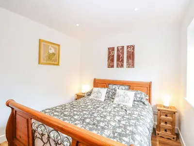 a bedroom with a bed and two pictures on the wall at Walnut Shade in Attleborough