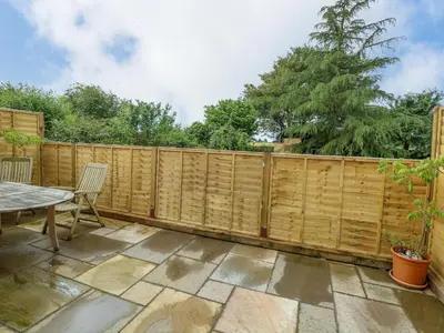 a wooden fence with a table and chairs on a patio at Walnut Shade in Attleborough