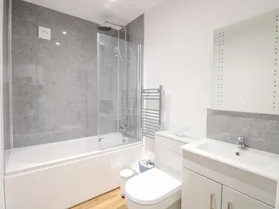 a bathroom with a tub and a toilet and a sink at Walnut Shade in Attleborough