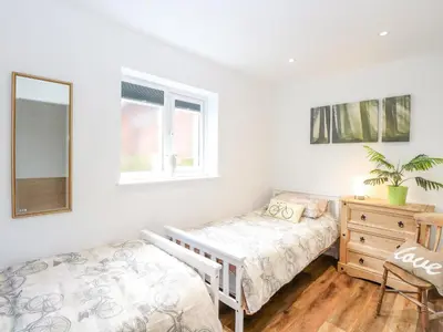 a bedroom with a bed and a dresser and a mirror at Walnut Shade in Attleborough