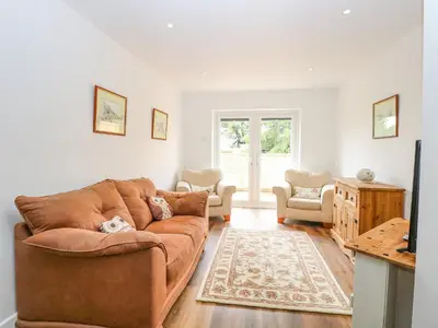a living room with a brown couch and a tv at Walnut Shade in Attleborough