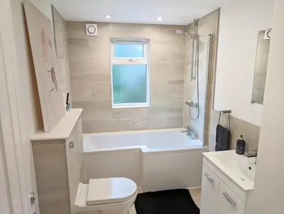 a bathroom with a tub and a toilet and a sink at CENTRAL CAMBRIDGE, CHARMING 3-Bed HOUSE WITH FREE PARKING! in Cambridge