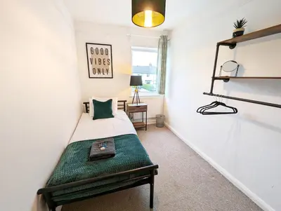 a small bedroom with a bed with a green blanket at CENTRAL CAMBRIDGE, CHARMING 3-Bed HOUSE WITH FREE PARKING! in Cambridge
