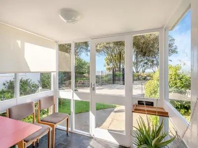 a room with large windows and a table and chairs at Beach View Cottage in Felixstowe