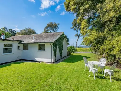 a house with chairs and a table in a yard at Beach View Cottage in Felixstowe