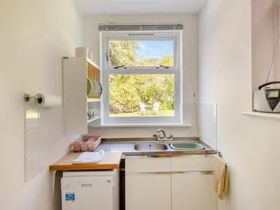 a small kitchen with a sink and a window at Beach View Cottage in Felixstowe