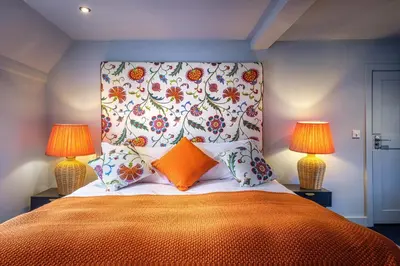 a bedroom with a large bed with two lamps at The Carpenters Arms in Great Wilbraham
