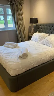 a bed with towels on top of it with a window at The Oaks Stable cottage in Haughley