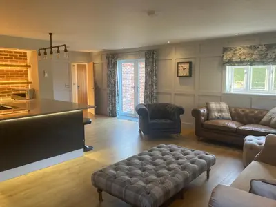 a living room with a couch and a flat screen tv at The Oaks Stable cottage in Haughley